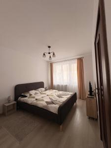 a bedroom with a bed and a window at Comodo Apartment in Turda