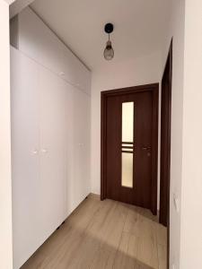 an empty room with a door and a wooden floor at Comodo Apartment in Turda