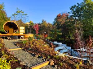 a garden with a pond and water slide at Bagoly-kő Panzió - Mátra Túraközpont in Parádsasvár