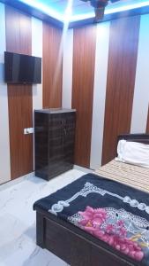 a room with a bed and a tv on the floor at anandam stay in Vrindāvan