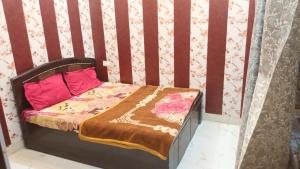 a small bed with two pink pillows on it at anandam stay in Vrindāvan +12 photos