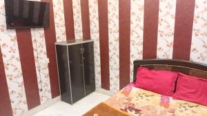 a room with a bed and a television in it at anandam stay in Vrindāvan