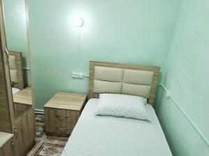 a small bedroom with a bed and a mirror at New Day Hostel in Yerevan