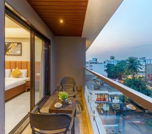 a balcony with a table and chairs and a bed at Hotel The Golden Oaks, Kolhapur in Kolhapur