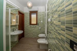 a bathroom with two toilets and a sink at La Vecchia Cascina in Atena Lucana