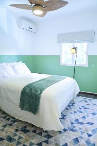 a bedroom with a white bed and a ceiling fan at Apto 3 quartos, confortável e silencioso- Ar Condicionado - Wi-Fi rápido - Ótima localização in Brasília