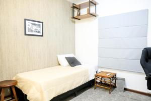 a small bedroom with a bed and a table at Apto 3 quartos, confortável e silencioso- Ar Condicionado - Wi-Fi rápido - Ótima localização in Brasília