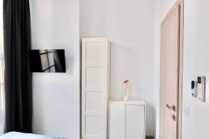 a bedroom with a white cabinet and a mirror at Central Suites Aegina 1 in Egina +48 photos
