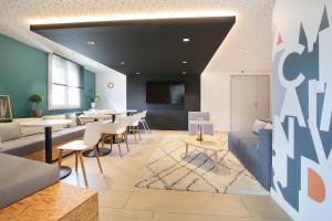 a living room with a couch and tables and chairs at Sweetly Isatis Mérignac Hôtel de ville in Mérignac
