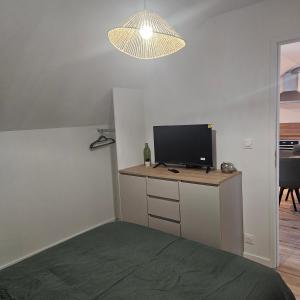 a bedroom with a desk with a television and a lamp at Lila in La Chapelle-de-Brain +8 photos