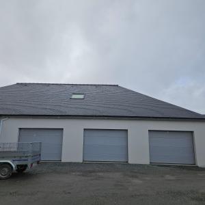 a garage with two garage doors and a truck parked in front at Lila in La Chapelle-de-Brain