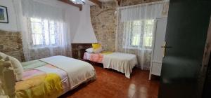 a bedroom with two beds and two windows at Complejo Rural Huerta Grande in Algeciras +117 photos