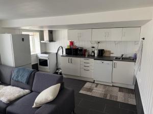 a living room with a couch and a kitchen at Arendal Sentrum Ro in Arendal
