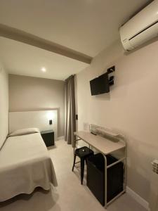 a hotel room with a bed and a desk at Pensión Coral in Barcelona