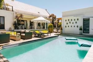a swimming pool in front of a house at Cape Diem Lodge in Cape Town