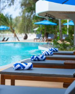 a row of swimming pools with blue umbrellas at Mafiya Resort in Koh Rong Island