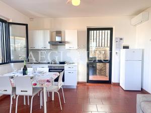 a kitchen with a table with chairs and a white refrigerator at Giglio Blu 1 in Campese