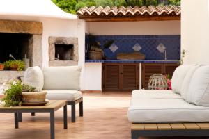 a living room with two white couches and a fireplace at Villamarina in Aglientu