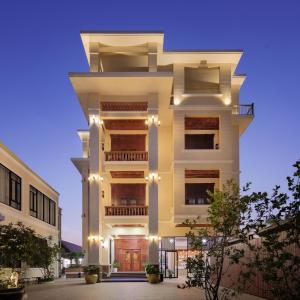 a tall white building with lights on it at Seyna Residence in Siem Reap