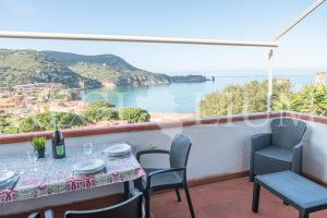 a table and chairs on a balcony with a view of the ocean at Giglio Blu 1 in Campese +7 photos