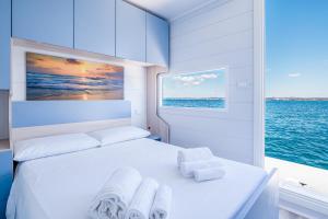 a white bed in a room with a window at Due Nodi by BarbarHouse in Gallipoli +10 photos