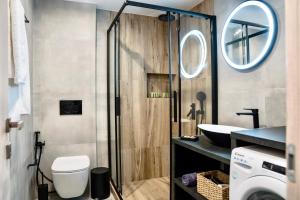 a bathroom with a shower and a toilet and a sink at Central Suites Aegina 2 in Egina +45 photos