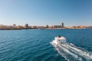 a boat in the water with a city in the background at Due Nodi by BarbarHouse in Gallipoli