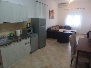 a kitchen with a refrigerator and a couch in a room at Apartmani Vujovic Markovici in Budva