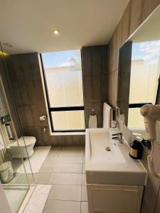 a bathroom with a sink and a toilet and a mirror at Hotel Lac Leman, LES BERGES DU LAC in Tunis +29 photos