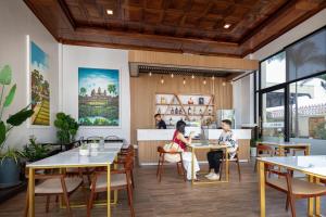 a restaurant with tables and people sitting at them at Seyna Residence in Siem Reap