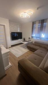 a living room with a couch and a flat screen tv at Čiurlioniada Apartment in Druskininkai +2 photos