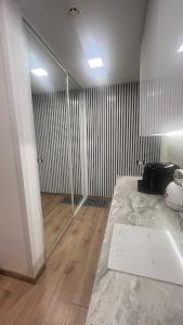 a bathroom with a sink and a glass door at Čiurlioniada Apartment in Druskininkai