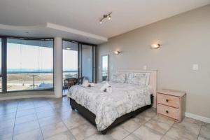 a bedroom with a bed and a view of the ocean at 302 Hibernian Towers Self Catering Accommodation in Strand +8 photos