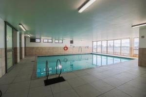 a large swimming pool in a large building at 302 Hibernian Towers Self Catering Accommodation in Strand