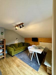a living room with a green couch and a table at Gästehaus Alpvital in Klais