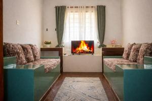 a living room with two couches and a fireplace at Elephant Villa Diani in Ukunda