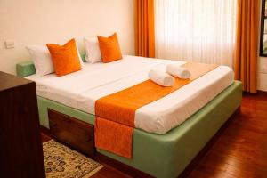 a bedroom with a bed with two towels on it at Elephant Villa Diani in Ukunda +20 photos