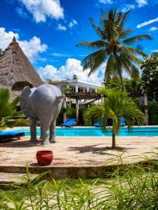a statue of an elephant in front of a pool at Elephant Villa Diani in Ukunda