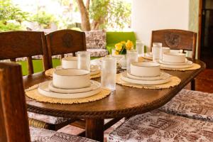 a wooden table with plates and dishes on it at Elephant Villa Diani in Ukunda