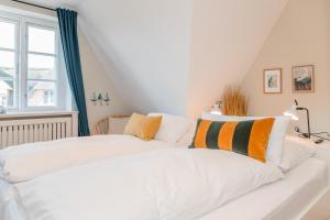 a white bed in a room with a window at Waaster Bob in Oldsum