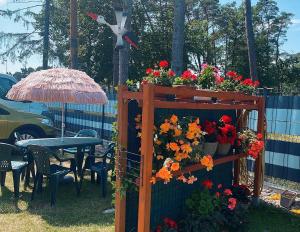 a garden with a table and flowers on a fence at Sternik Dom gościnny in Niechorze