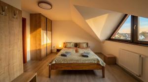a bedroom with a bed with a large window at Biely Dom in Ružomberok
