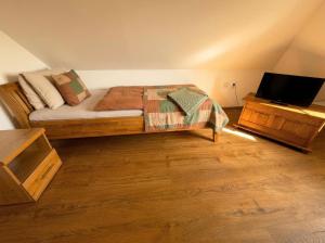 a bedroom with a bed and a tv on a table at Biely Dom in Ružomberok