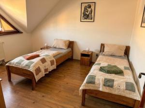 two beds in a room with wooden floors at Biely Dom in Ružomberok +10 photos