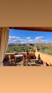 a view of a patio with a table and chairs at Les Jardins du M'goun in El Kelaa des Mgouna