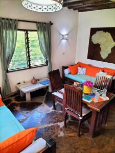 a living room with a table and chairs and a couch at Rischland Villas in Watamu
