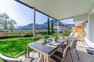 a patio with a table and chairs on a balcony at Haus Wiesenstein in Lana