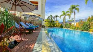 a swimming pool with chairs and an umbrella next to a building at Seyna Residence in Siem Reap