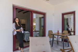 a woman standing in the doorway of a room at Glaucus Summer House sea view in Mandrakia +26 photos
