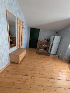 a room with a wooden floor and a refrigerator at Cousy Center House in Šiauliai